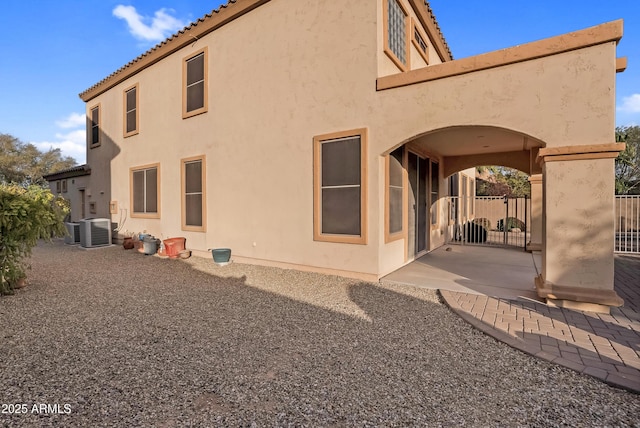 back of property with central AC and a patio area