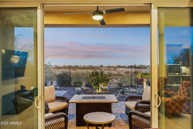 view of patio with ceiling fan and an outdoor living space with a fire pit