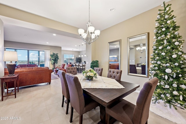 dining area with light tile patterned flooring and an inviting chandelier