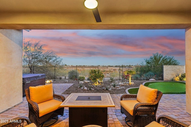 patio terrace at dusk with an outdoor living space and ceiling fan