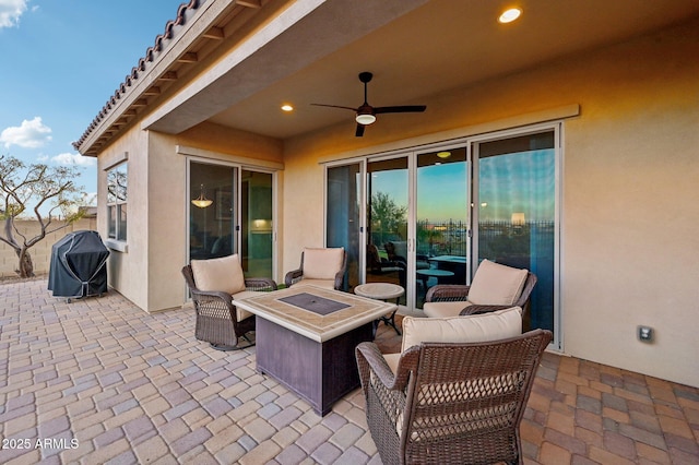 view of patio / terrace with a fire pit, ceiling fan, and a grill