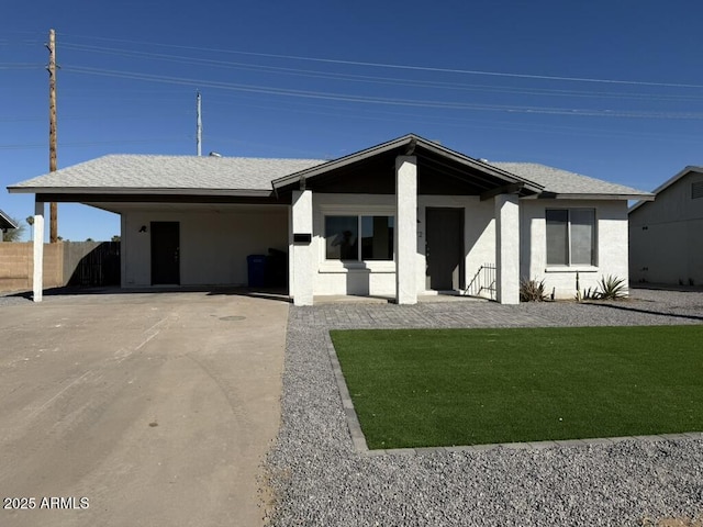 ranch-style house featuring a front lawn and a carport