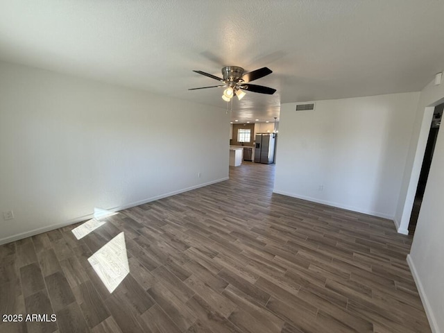 unfurnished living room with dark hardwood / wood-style floors and ceiling fan