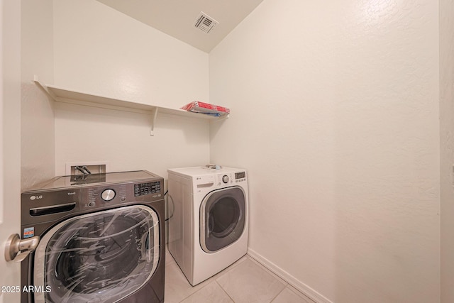 7648 W Kerby Ave, Phoenix, AZ 85043 - laundry area featuring washing machine and clothes dryer, light tile patterned flooring, and baseboards
