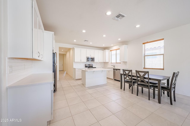 7648 W Kerby Ave, Phoenix, AZ 85043 - kitchen featuring appliances with stainless steel finishes, recessed lighting, decorative backsplash, white cabinetry, and a center island