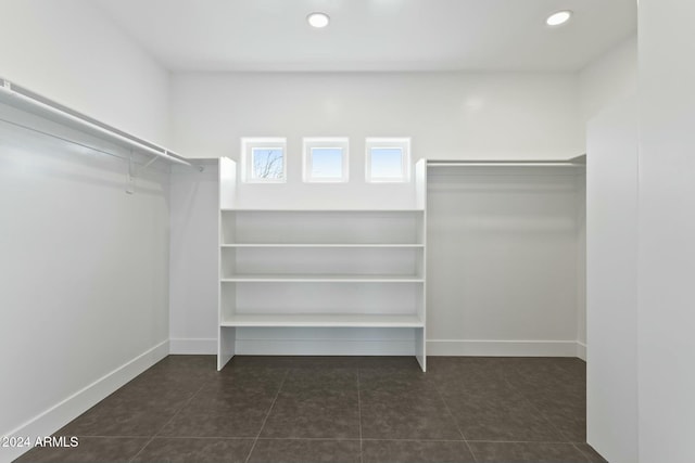 walk in closet featuring dark tile patterned floors