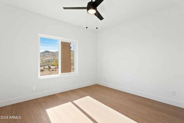 empty room with ceiling fan and hardwood / wood-style floors