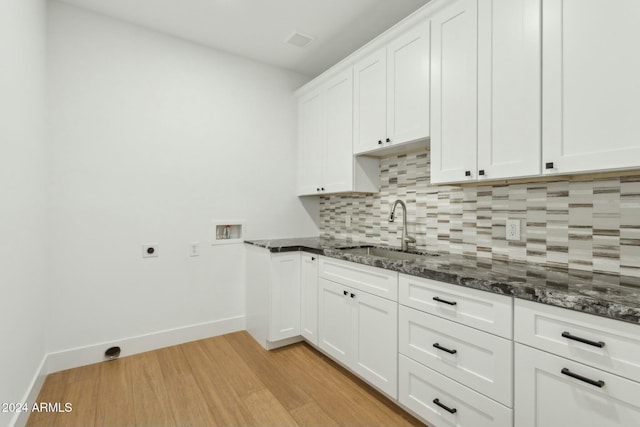 kitchen with decorative backsplash, sink, white cabinets, and light hardwood / wood-style floors