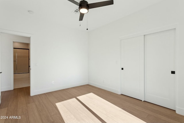 unfurnished bedroom featuring light wood-type flooring, a closet, and ceiling fan