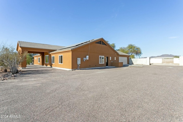 view of side of property with solar panels and a garage