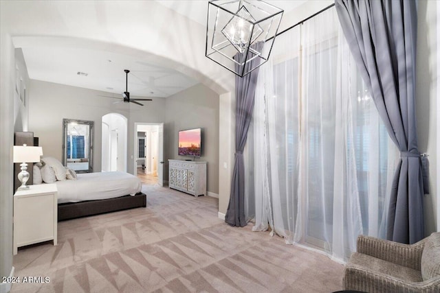 bedroom with ceiling fan with notable chandelier and light carpet