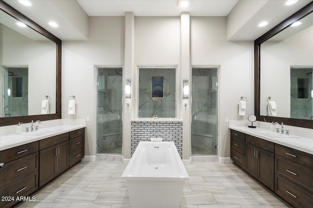 bathroom featuring vanity and independent shower and bath