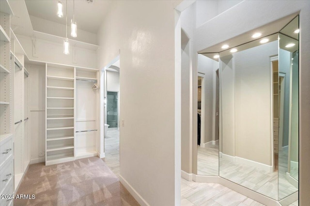 walk in closet featuring light carpet