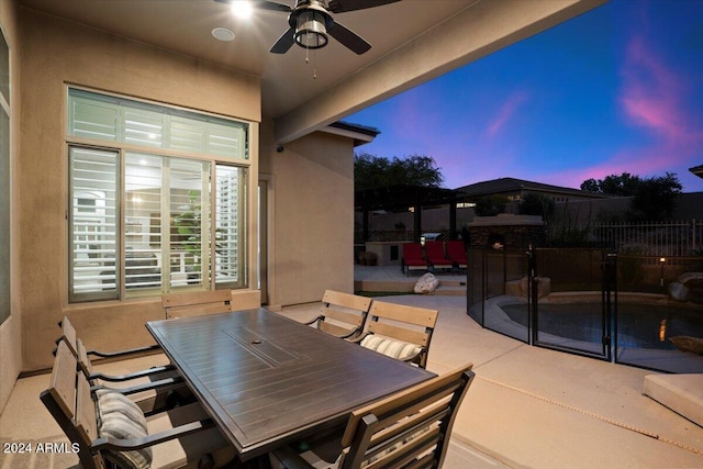 patio terrace at dusk featuring ceiling fan