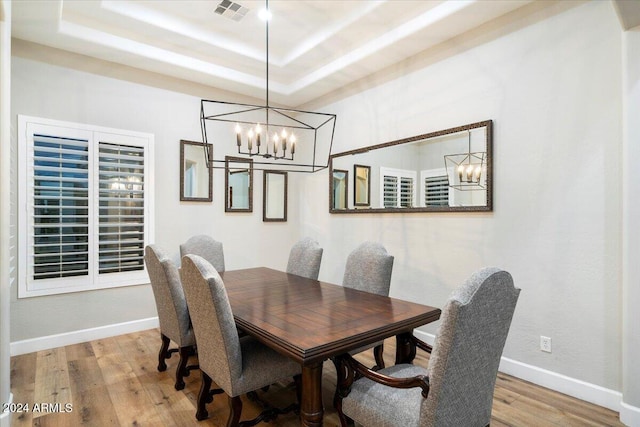 dining space with hardwood / wood-style flooring and a tray ceiling