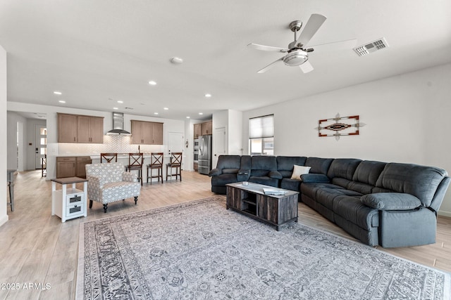 living room with light hardwood / wood-style flooring and ceiling fan