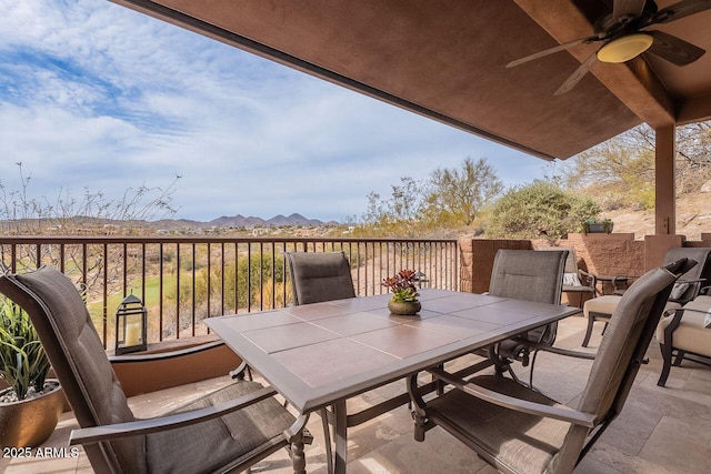 balcony with ceiling fan, outdoor dining area, and a mountain view