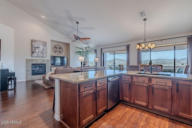 kitchen with visible vents, a tile fireplace, lofted ceiling, a sink, and stainless steel dishwasher