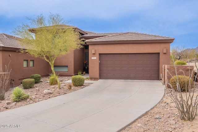 view of front of home with a garage, a tile roof, driveway, and stucco siding