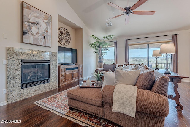 living area featuring a fireplace, wood finished floors, visible vents, and baseboards