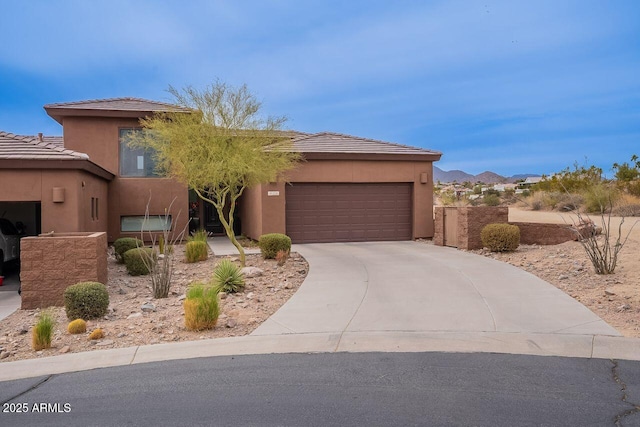 view of front of property featuring driveway, an attached garage, and stucco siding