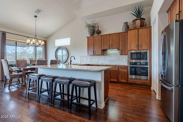 kitchen with stainless steel appliances, a sink, and brown cabinets