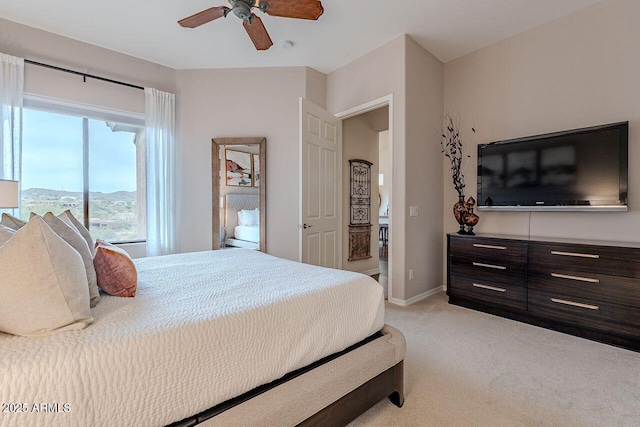 bedroom featuring a ceiling fan, light carpet, and baseboards