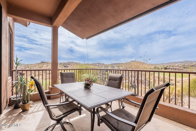 balcony with outdoor dining space and a mountain view