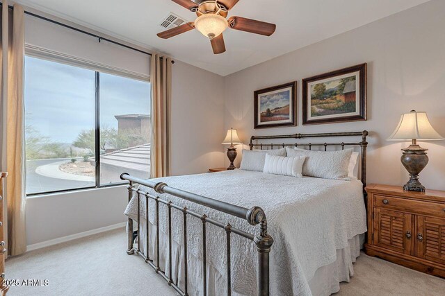 bedroom with light colored carpet, visible vents, ceiling fan, and baseboards