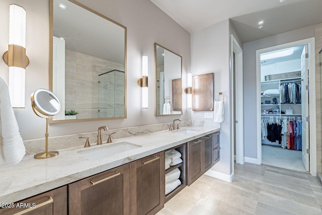 full bath with a stall shower, a sink, a spacious closet, and double vanity