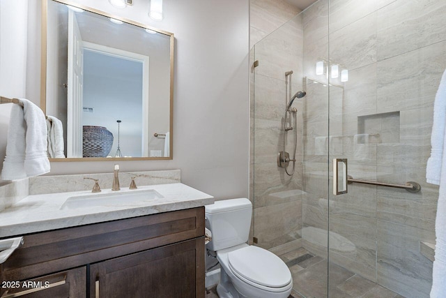 full bathroom featuring a stall shower, vanity, and toilet