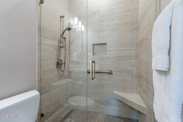 bathroom with a shower stall and toilet