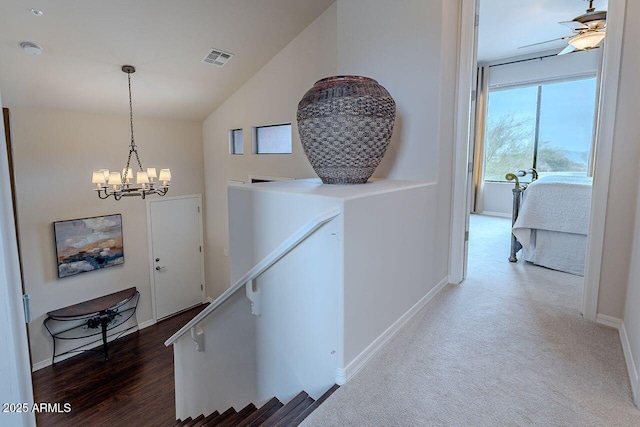 hallway with baseboards, visible vents, a chandelier, an upstairs landing, and high vaulted ceiling