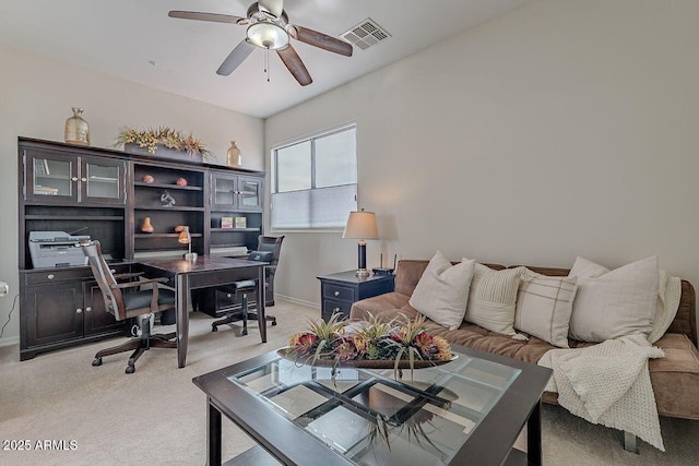 office space with light colored carpet, visible vents, ceiling fan, and baseboards