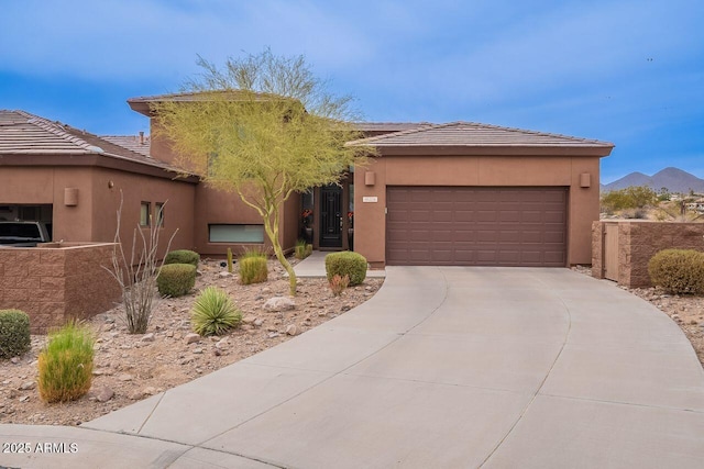 view of front facade featuring an attached garage, driveway, a tile roof, and stucco siding