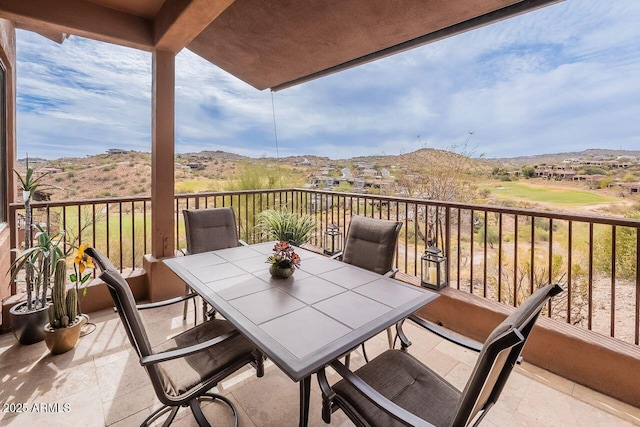 balcony with outdoor dining area and a mountain view