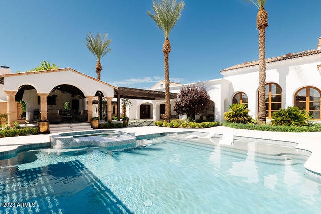 view of swimming pool featuring a patio area and an in ground hot tub