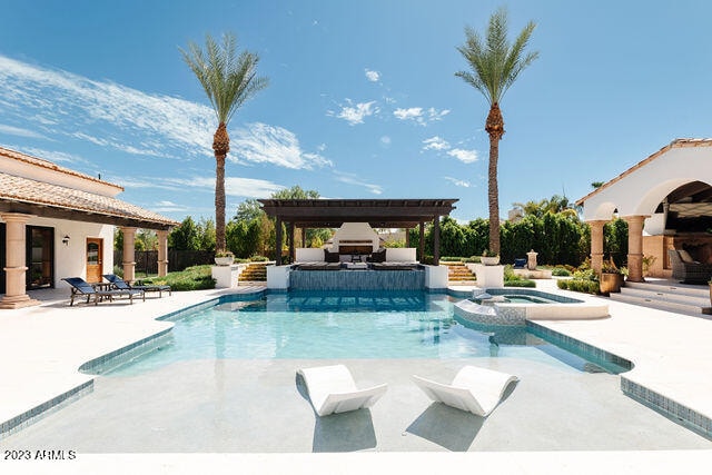 view of swimming pool featuring a pergola, a patio area, an in ground hot tub, and an outdoor fireplace