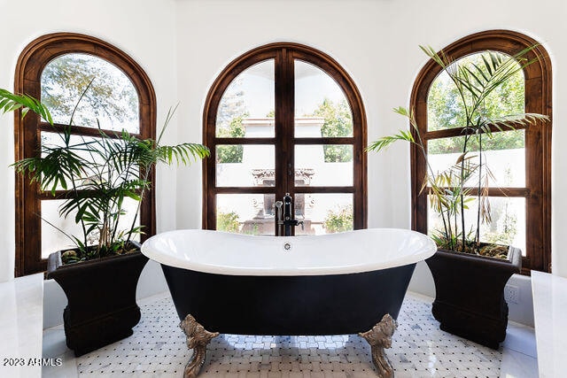 interior space with french doors, a healthy amount of sunlight, and tile floors