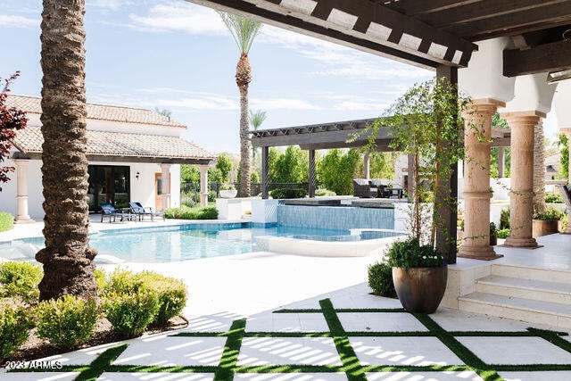 view of swimming pool with a patio and a hot tub