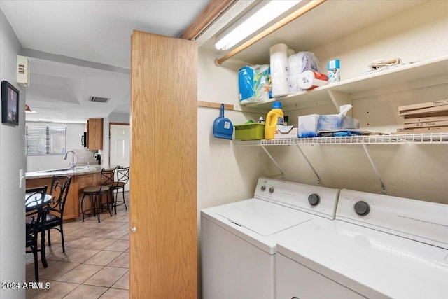 washroom featuring washer and dryer, light tile patterned floors, and sink