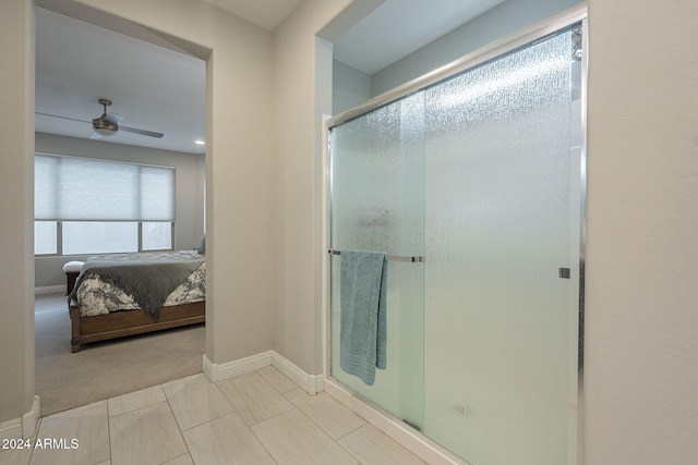 bathroom featuring ceiling fan and a shower with door