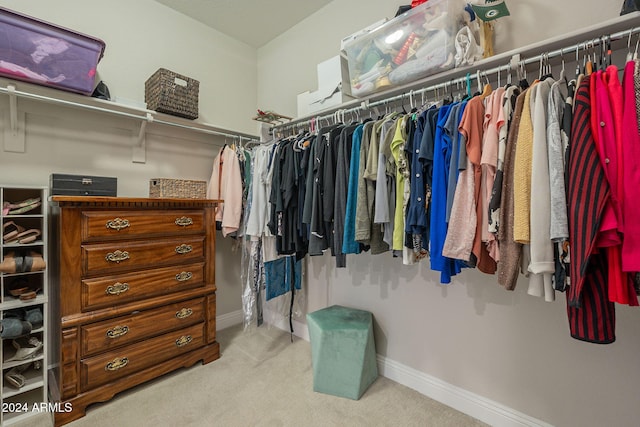 walk in closet with light carpet