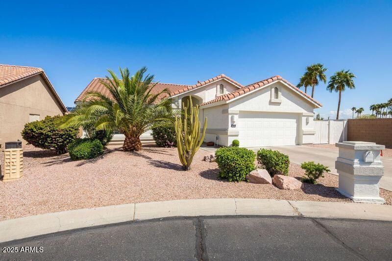 15516 W Verde Ln, Goodyear, AZ 85395 - view of front facade with a tile roof, concrete driveway, stucco siding, fence, and an attached garage