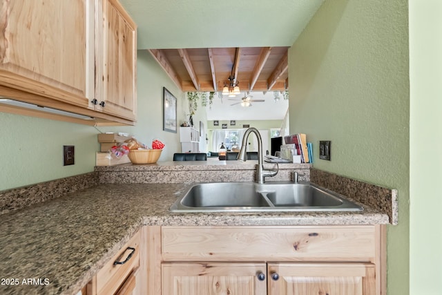 kitchen with ceiling fan, beam ceiling, a sink, and light brown cabinetry