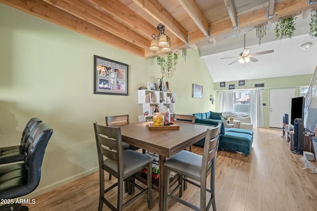 dining space with visible vents, baseboards, a ceiling fan, light wood-style flooring, and vaulted ceiling with beams