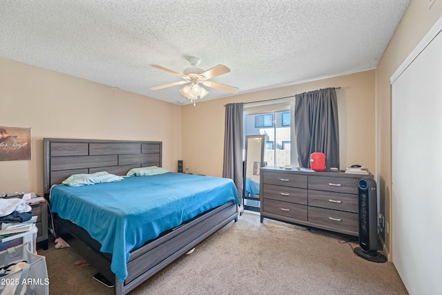 bedroom featuring ceiling fan, a textured ceiling, and light colored carpet