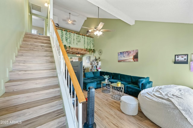 living room with visible vents, lofted ceiling with beams, ceiling fan, wood finished floors, and stairs