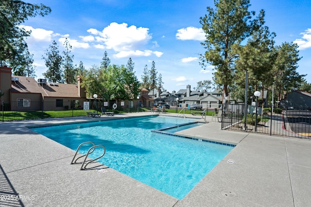 pool featuring a residential view, a patio area, and fence