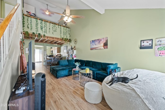 living room featuring a ceiling fan, high vaulted ceiling, beamed ceiling, and wood finished floors